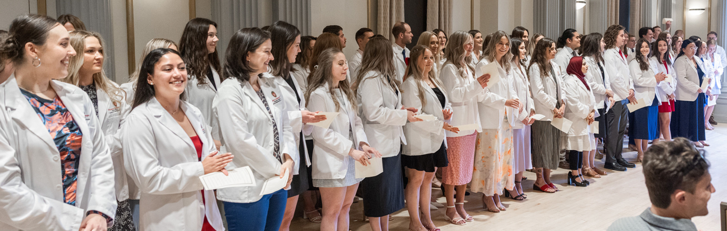 A large group of students in their white coats
