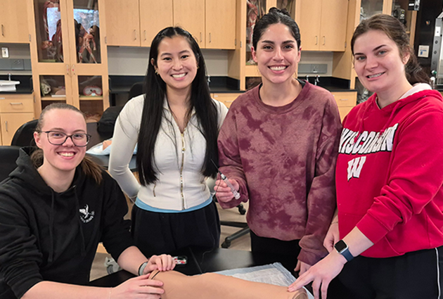PA students working together on a mannequin in a lab