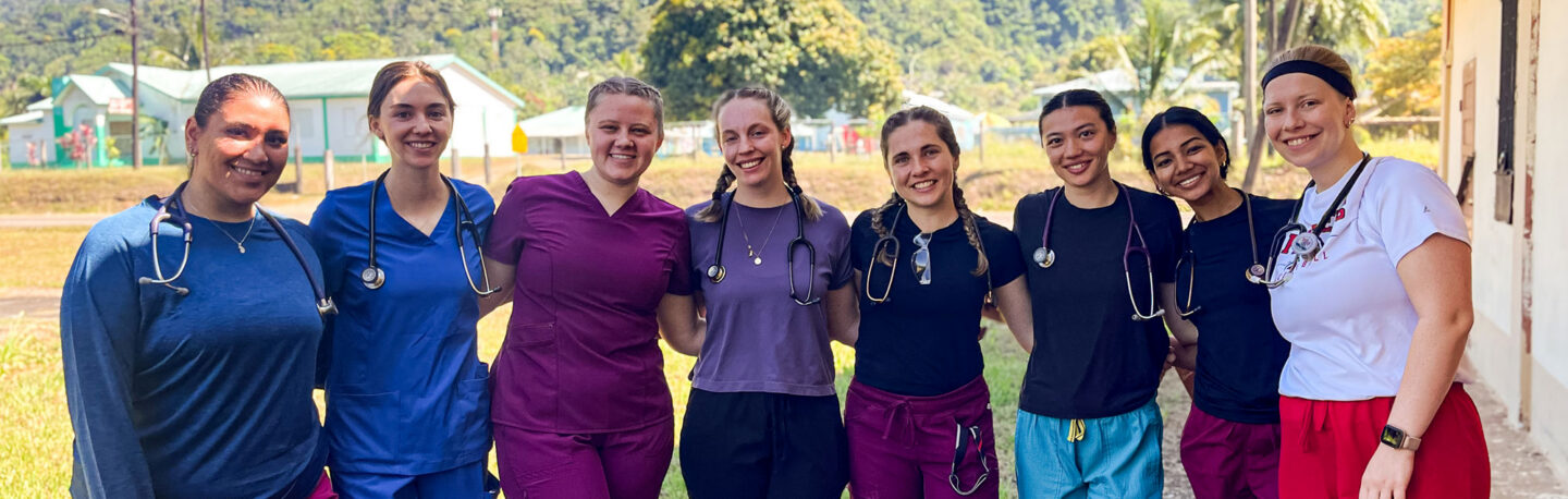 A group of smiling health professions students on a service-learning trip