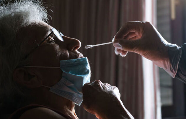 nursing home patient has nose swabbed for flu test