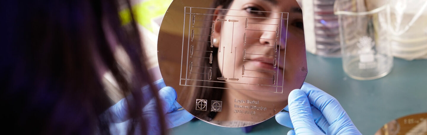 A woman looking at a reflective object in a lab environment