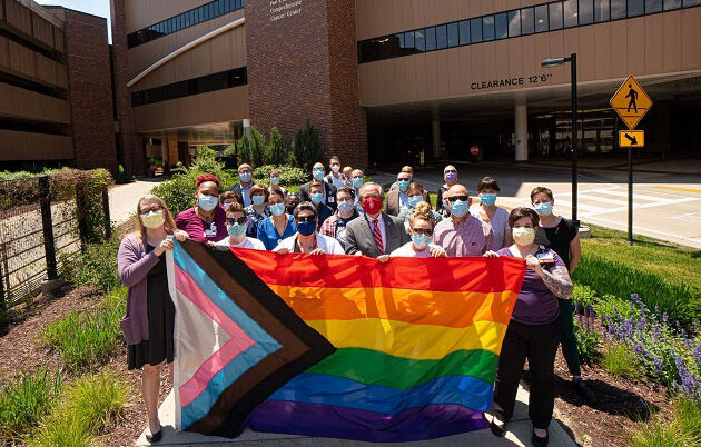 Group of people holding LGBTQ+flag