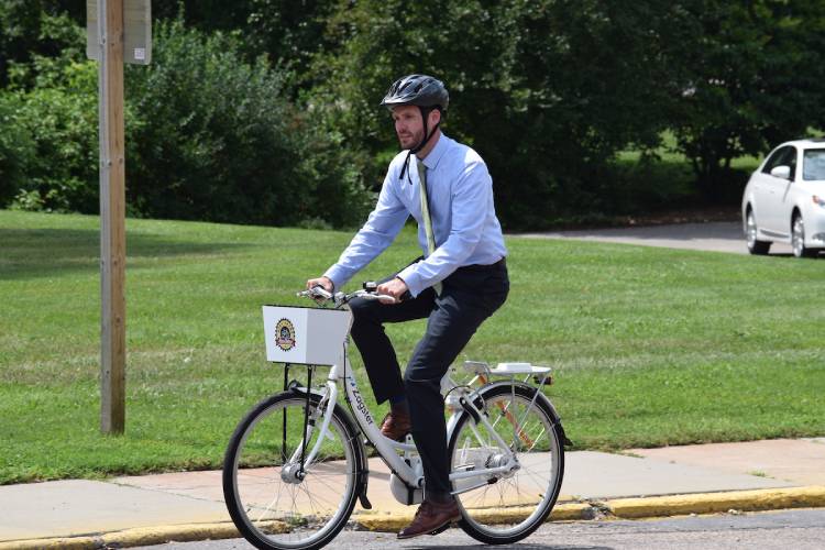 A man riding a bike dressed in business attire
