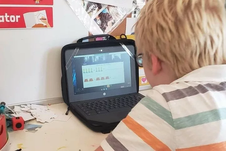 An elementary school student working on a laptop